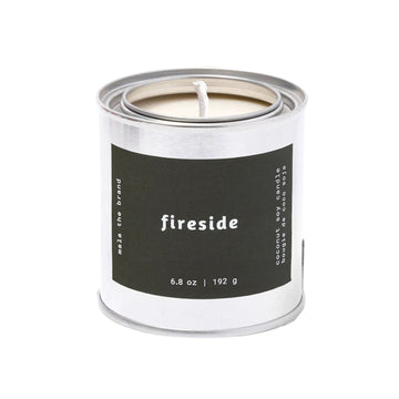Candle in a metal canister labeled 'fireside' on a white background