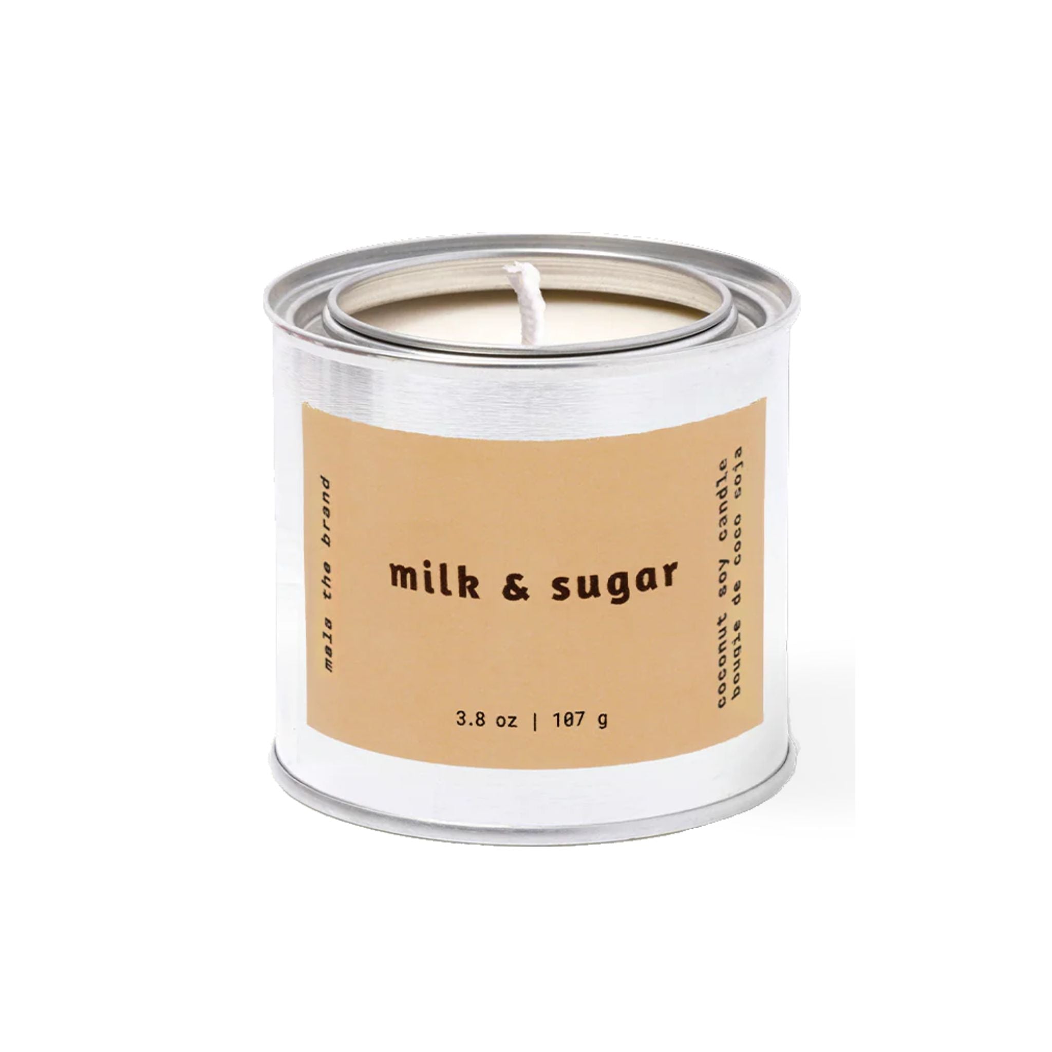 Candle in a white container with a brown label reading 'milk & sugar' on a white background.