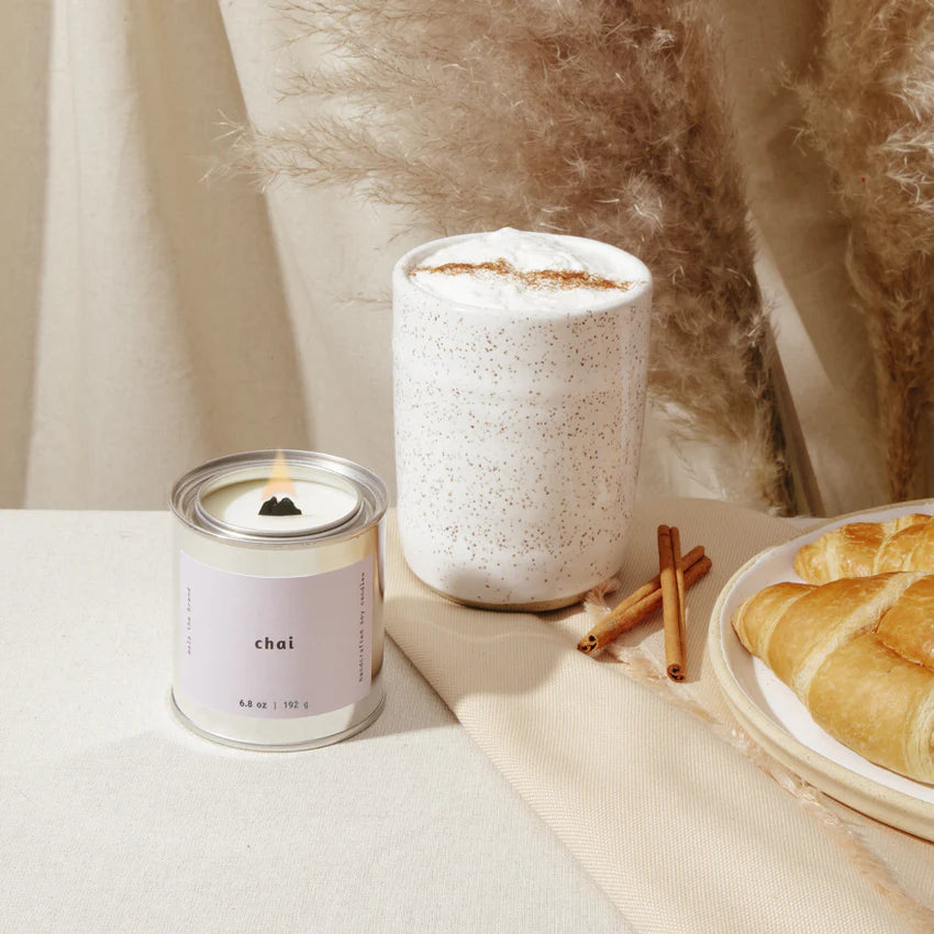 Chai candle and glass of chai latte on a table with decorative elements