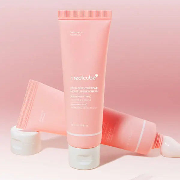 Pink skincare tube with white cap on a pink background
