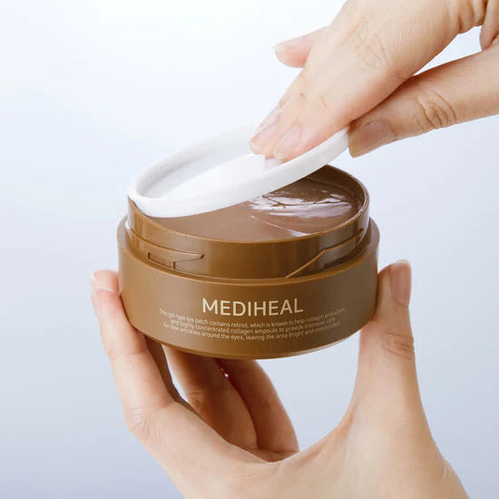 Hand holding a jar of Mediheal cream with a white applicator on a light gray background