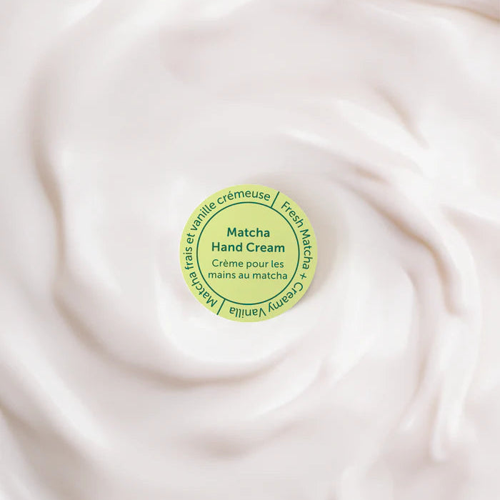 Matcha hand cream container on a swirling cream background