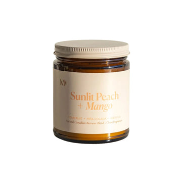 Jar of 'Sunlit Peach + Mango' candle on a white background
