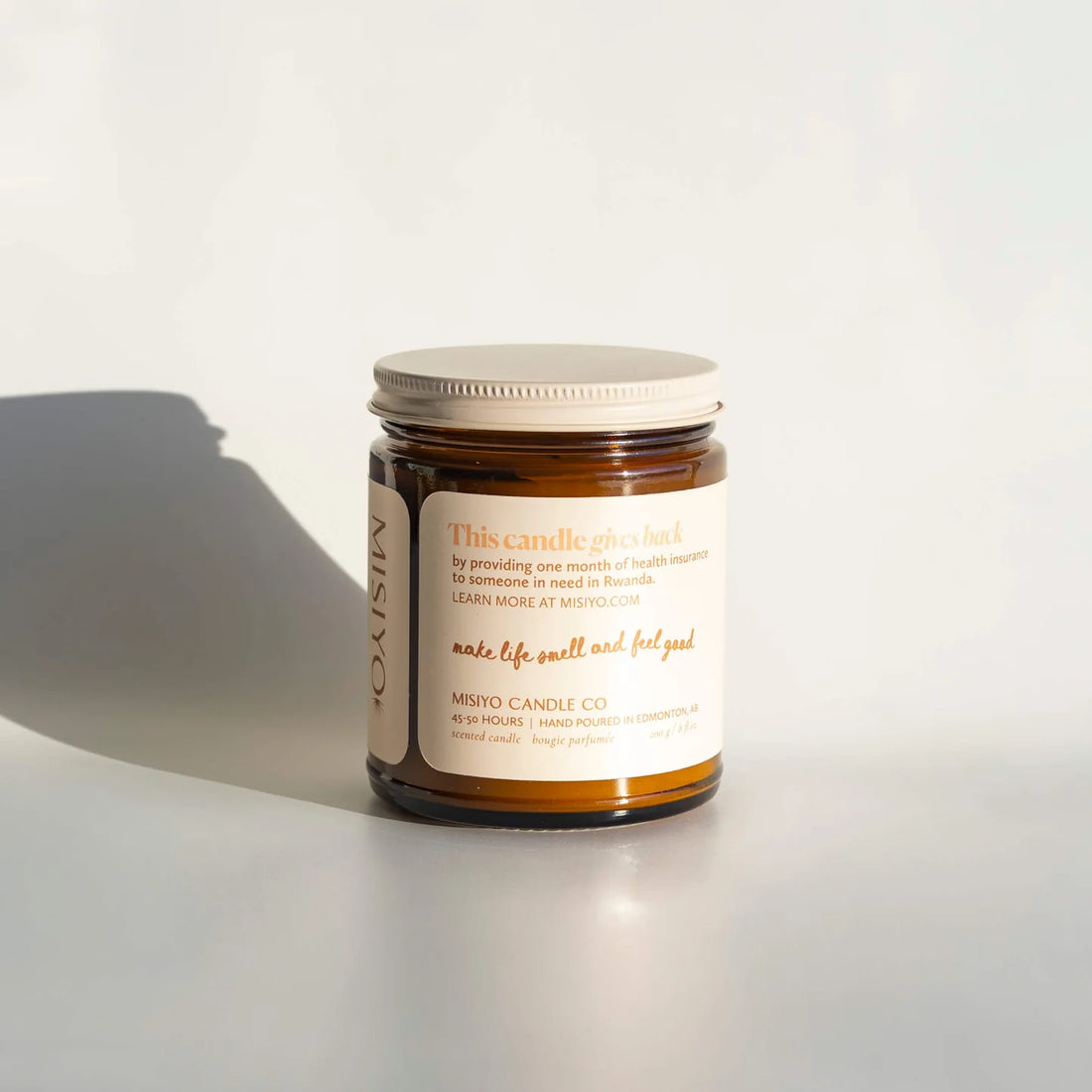 Jar of 'Sunlit Peach + Mango' candle on a white background