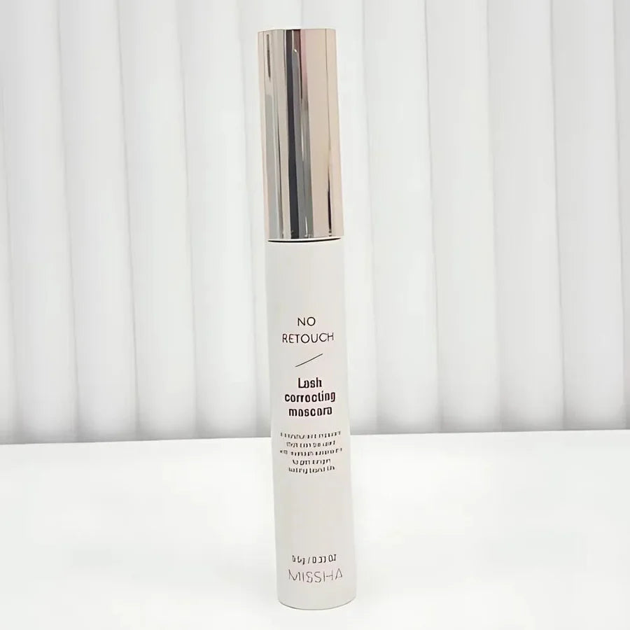 Lash correcting mascara tube with silver cap on a white background