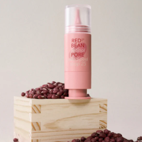 Pink skincare product with clear cap on a white background