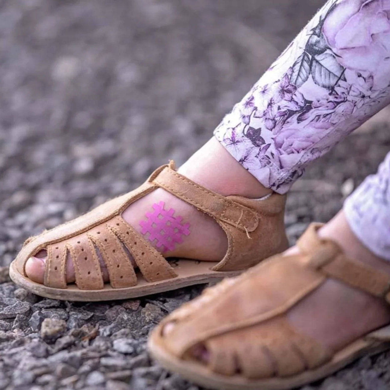 Brown sandals worn on a gravel surface