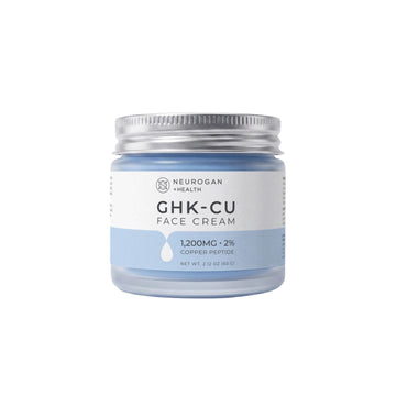 A jar of Neurogan + Health GHK-CU Face Cream with a light blue cream visible through the clear container, a white and light blue label, and a silver metal screw lid, set against a plain white background.