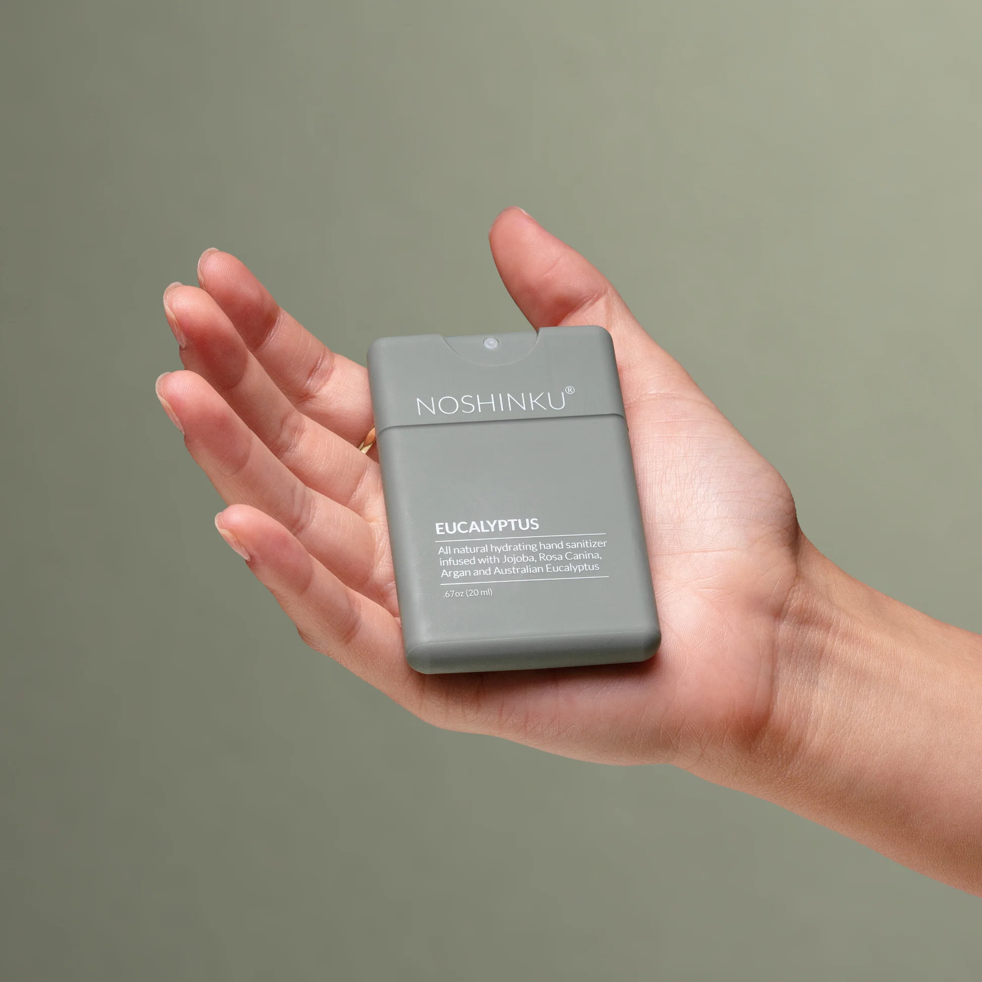 Hand holding a Noshinku eucalyptus product against a plain background