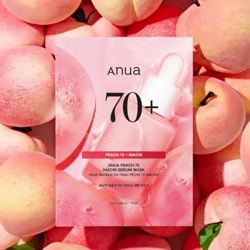 Anua 70+ Peach & Niacin serum mask packaging surrounded by peaches