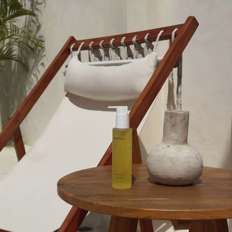 Skincare bottle on a wooden table with a vase and plant in the background