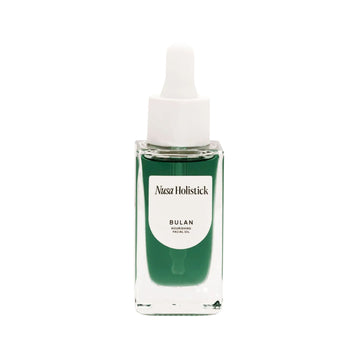 Green facial oil bottle with white cap on a white background