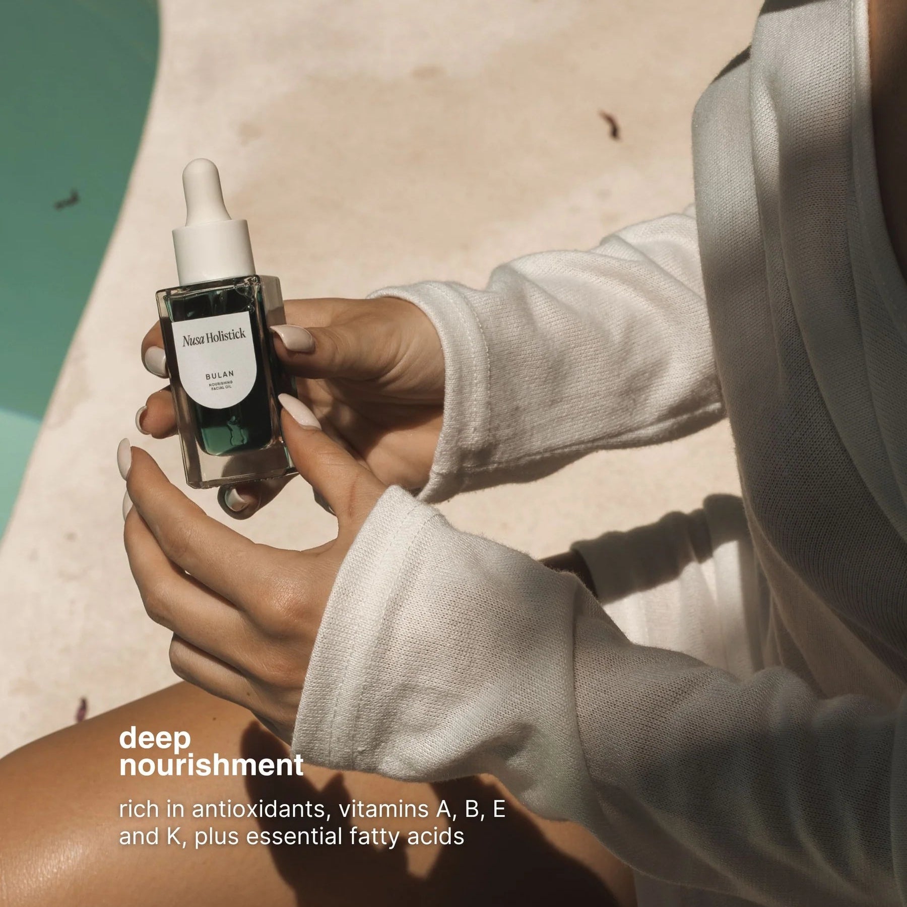 Person holding a skincare serum bottle with text about its benefits.