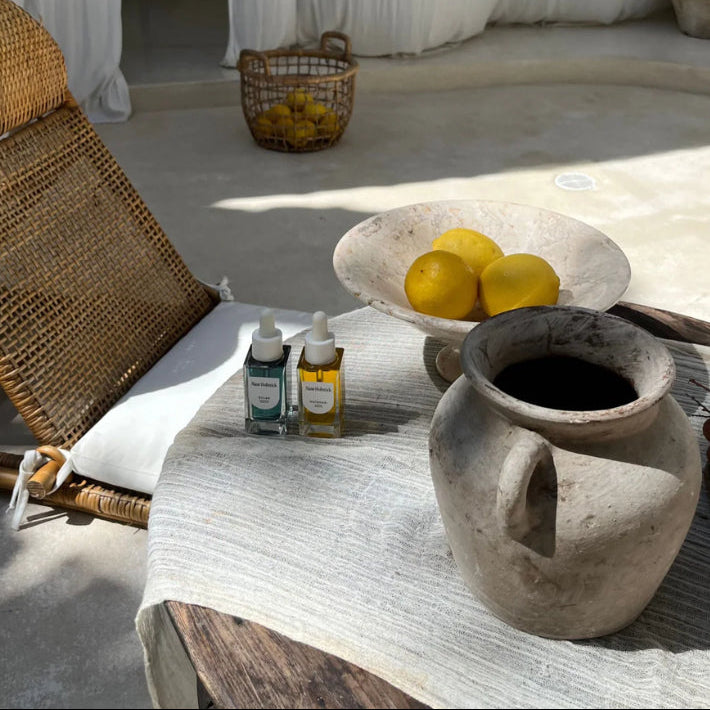 Outdoor setting with a wicker chair, table, and decorative items including lemons and a vase.