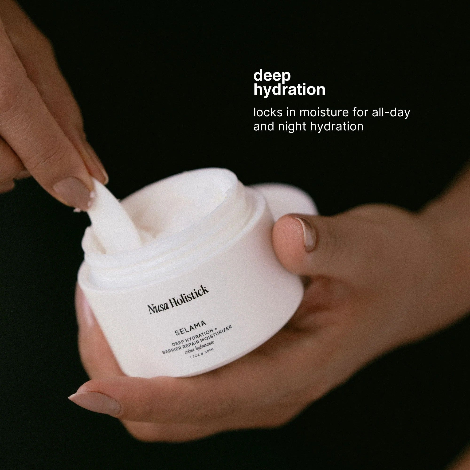 Nusa Holistick  Selama cream jar with a hand holding it against a black background