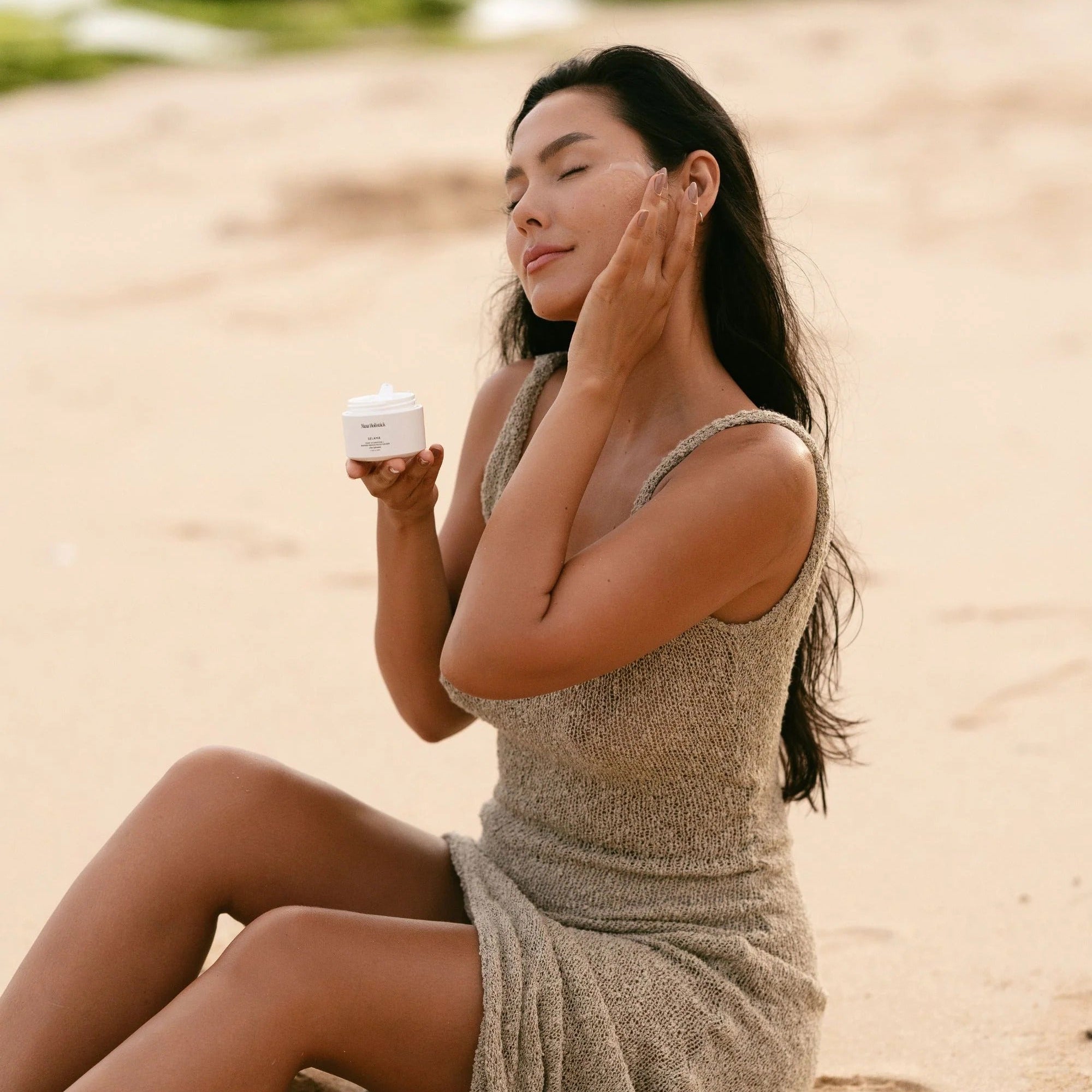 Woman applying sunscreen on a beach
