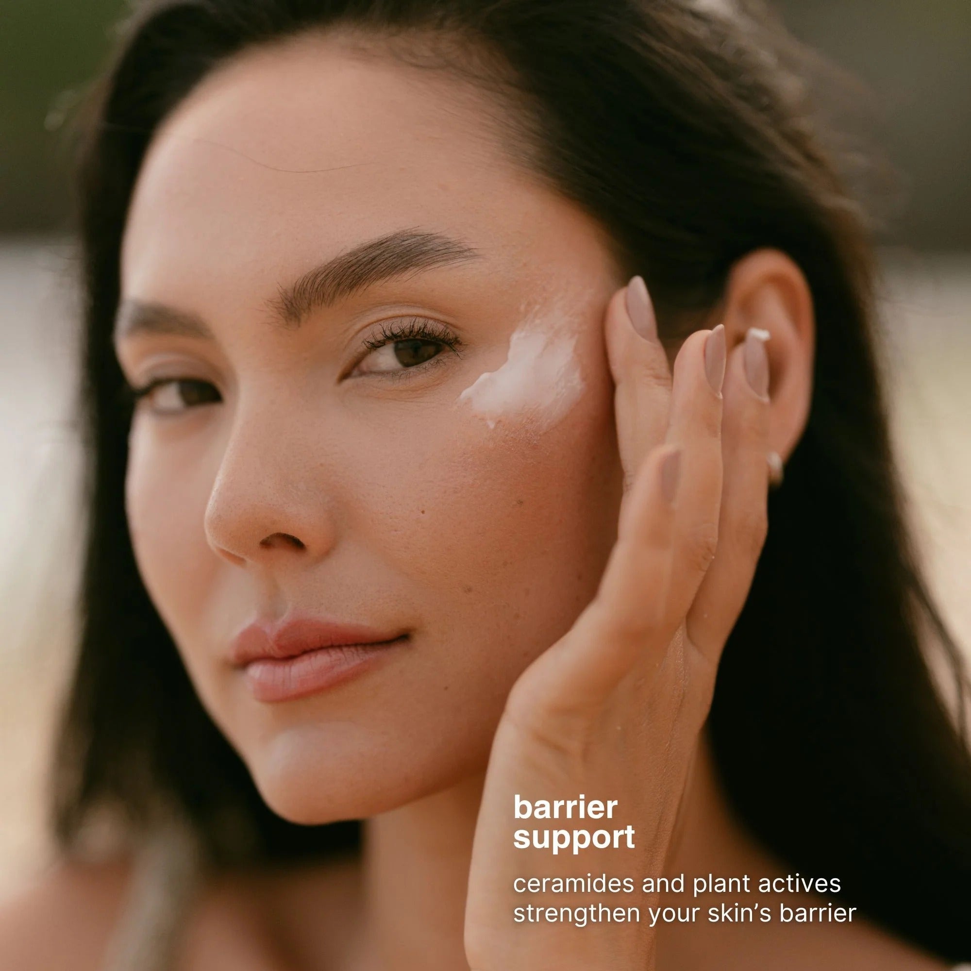 Woman applying cream to her face with a blurred background