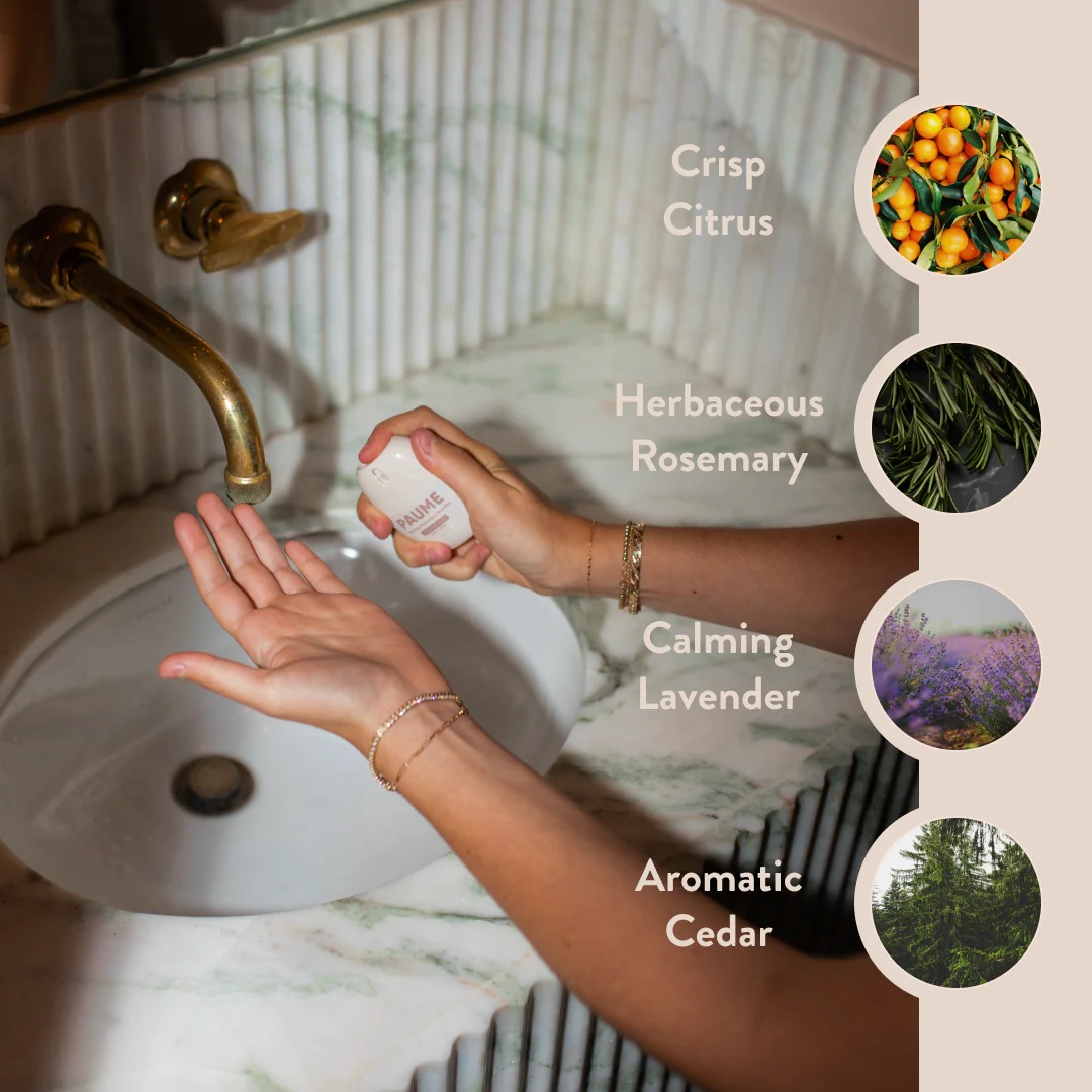 Person holding a bottle of hand soap with scents listed on a bathroom background