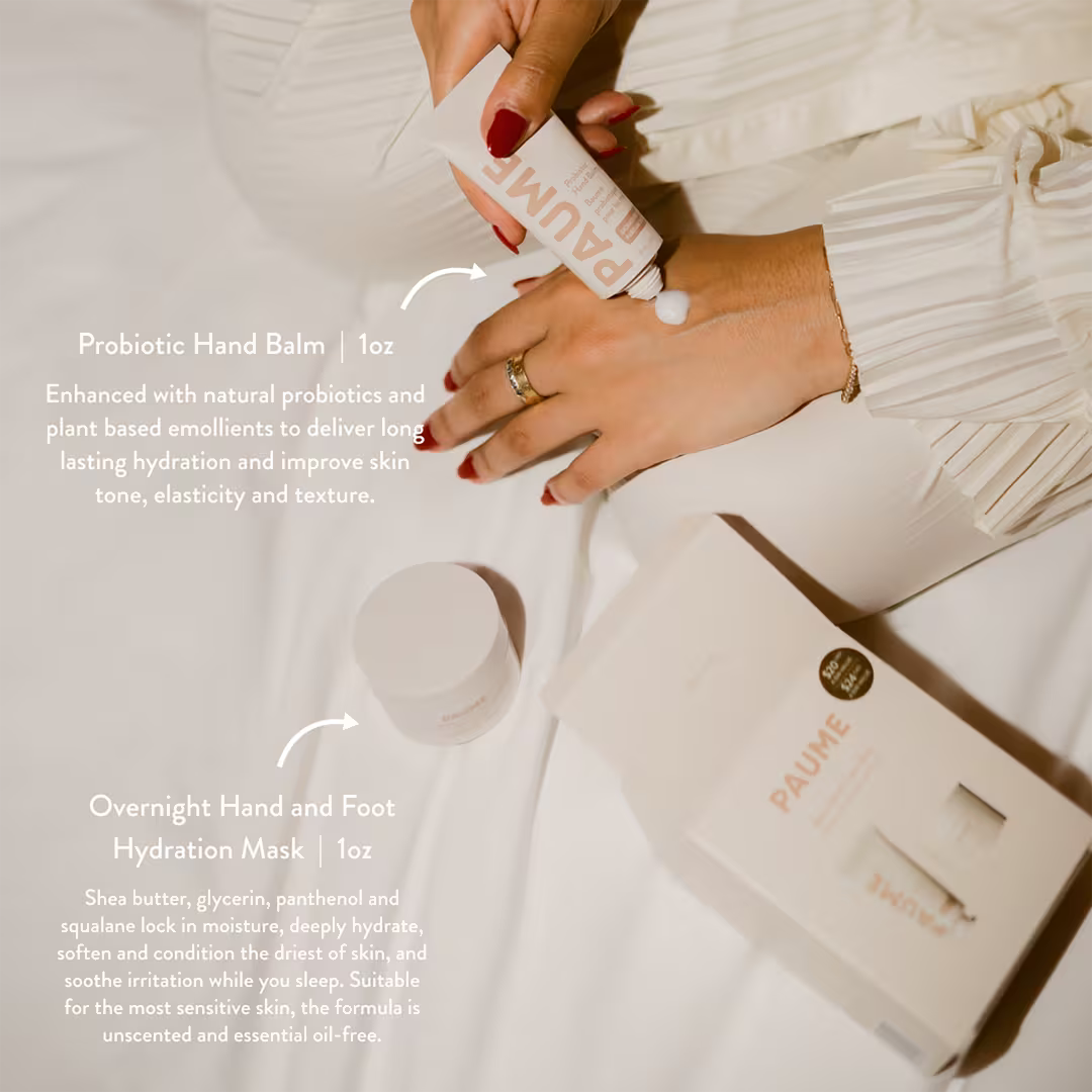 Hand applying hand balm with product packaging in the background