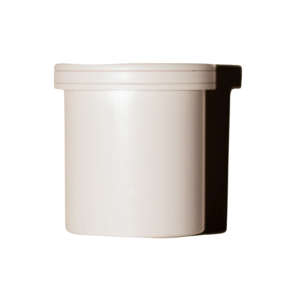 White cylindrical container with a black lid on a white background