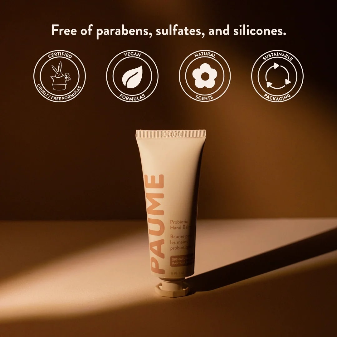 PAUME hand balm tube with certification icons on a brown background
