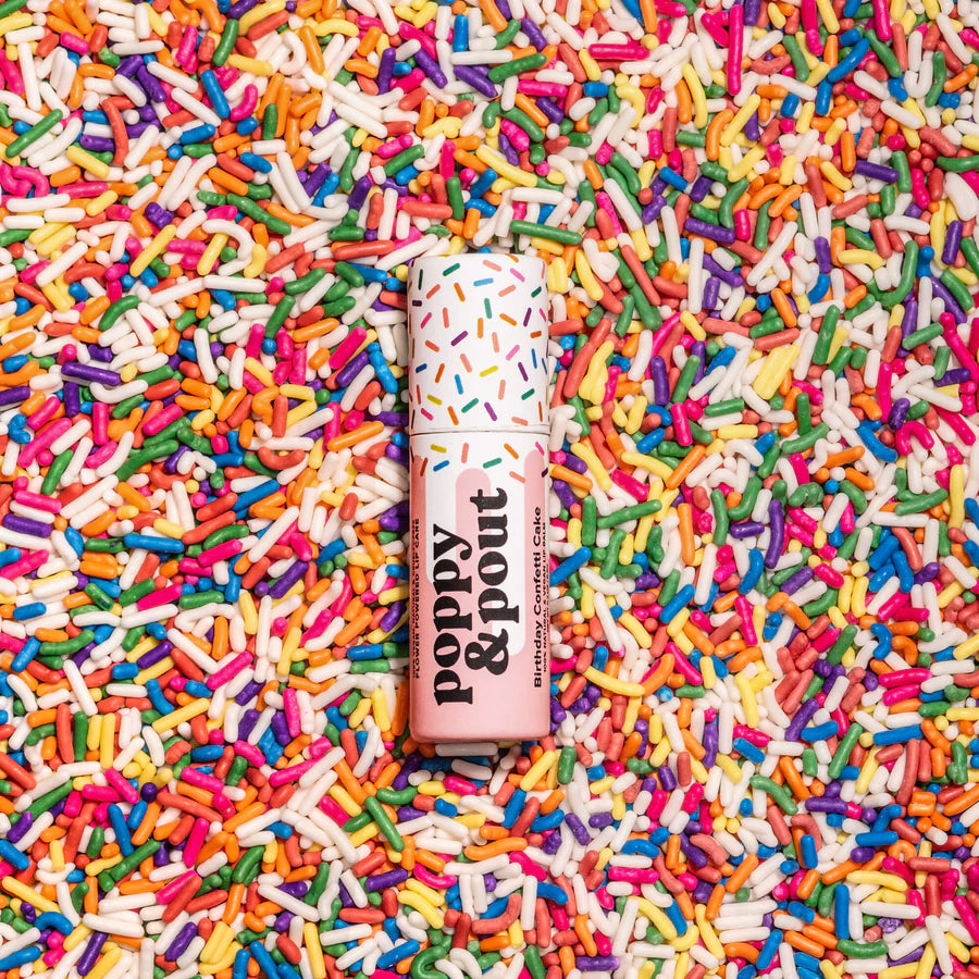 Lip balm with sprinkles on a bed of colorful sprinkles