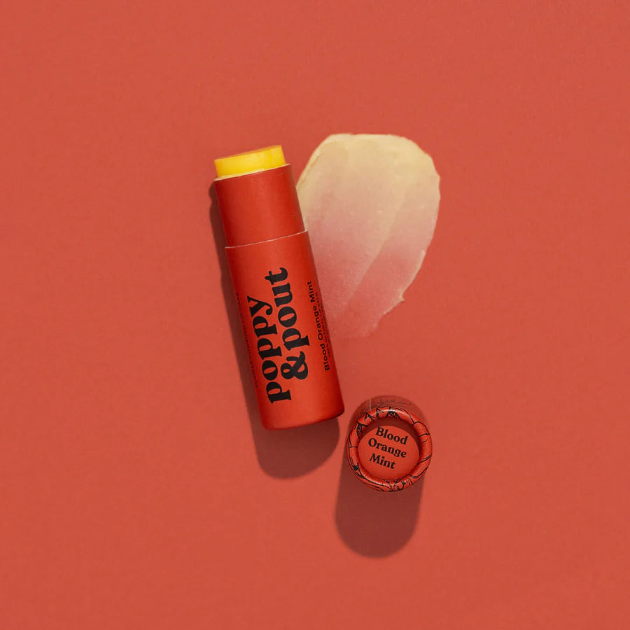Lip balm with red container and yellow cap on a red background
