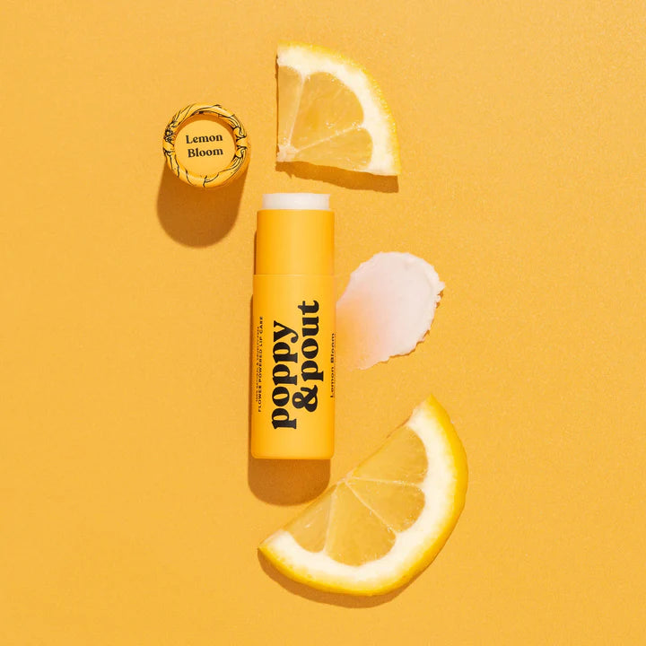 Poppy & Pout lip balm with lemon slices on a yellow background