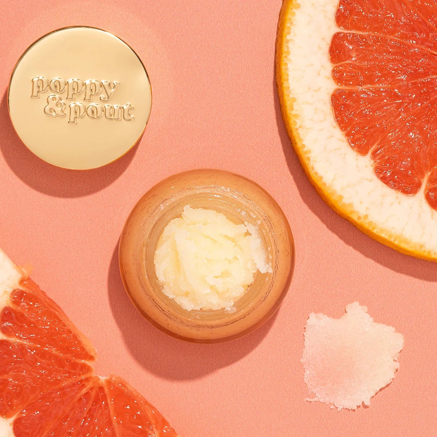 Jar of lip balm with a gold lid featuring 'Bath & Body Works' on a pink background with grapefruit slices.