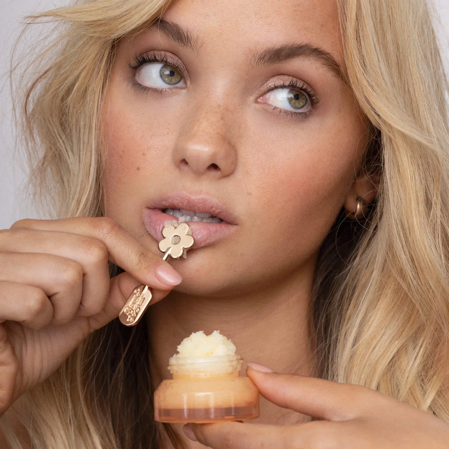 Woman holding a small dessert with a flower-shaped spoon