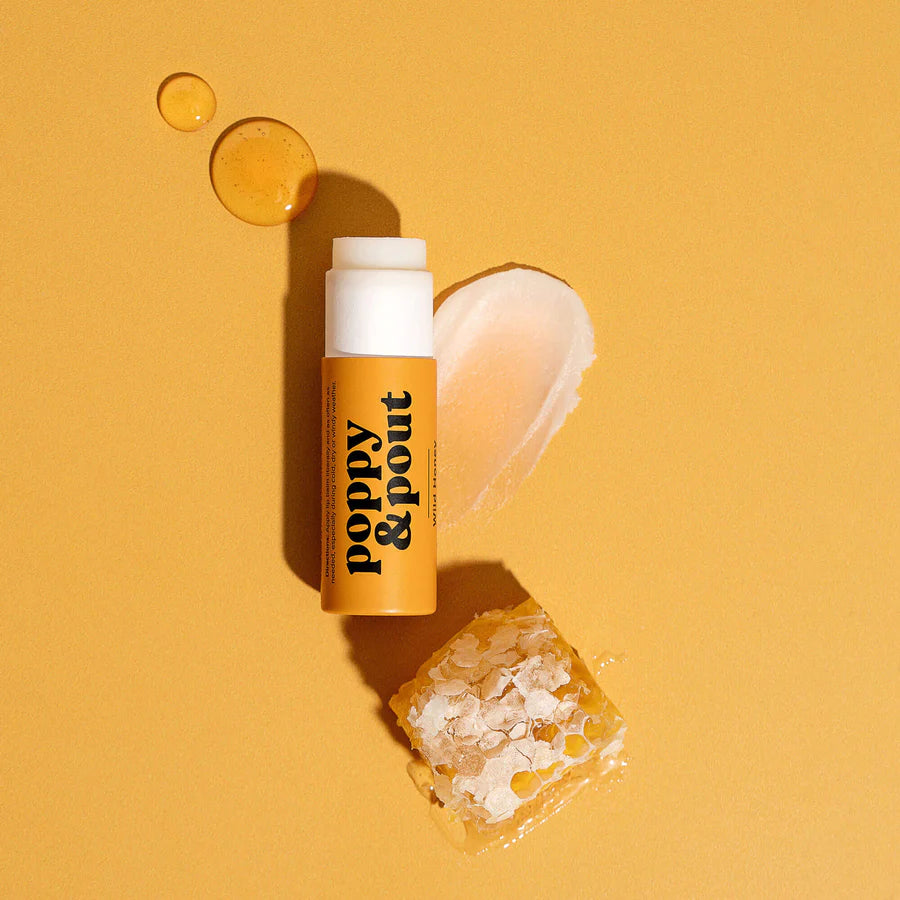 Poppy & Pout lip balm on a yellow background with product packaging.