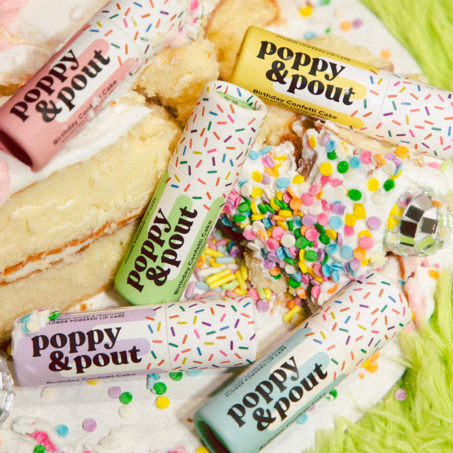 Poppy & Pout lip balm packaging with colorful sprinkles on a cake background