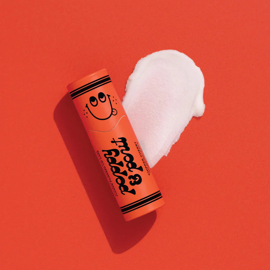Orange tube of whipped cream with a smiley face on a red background