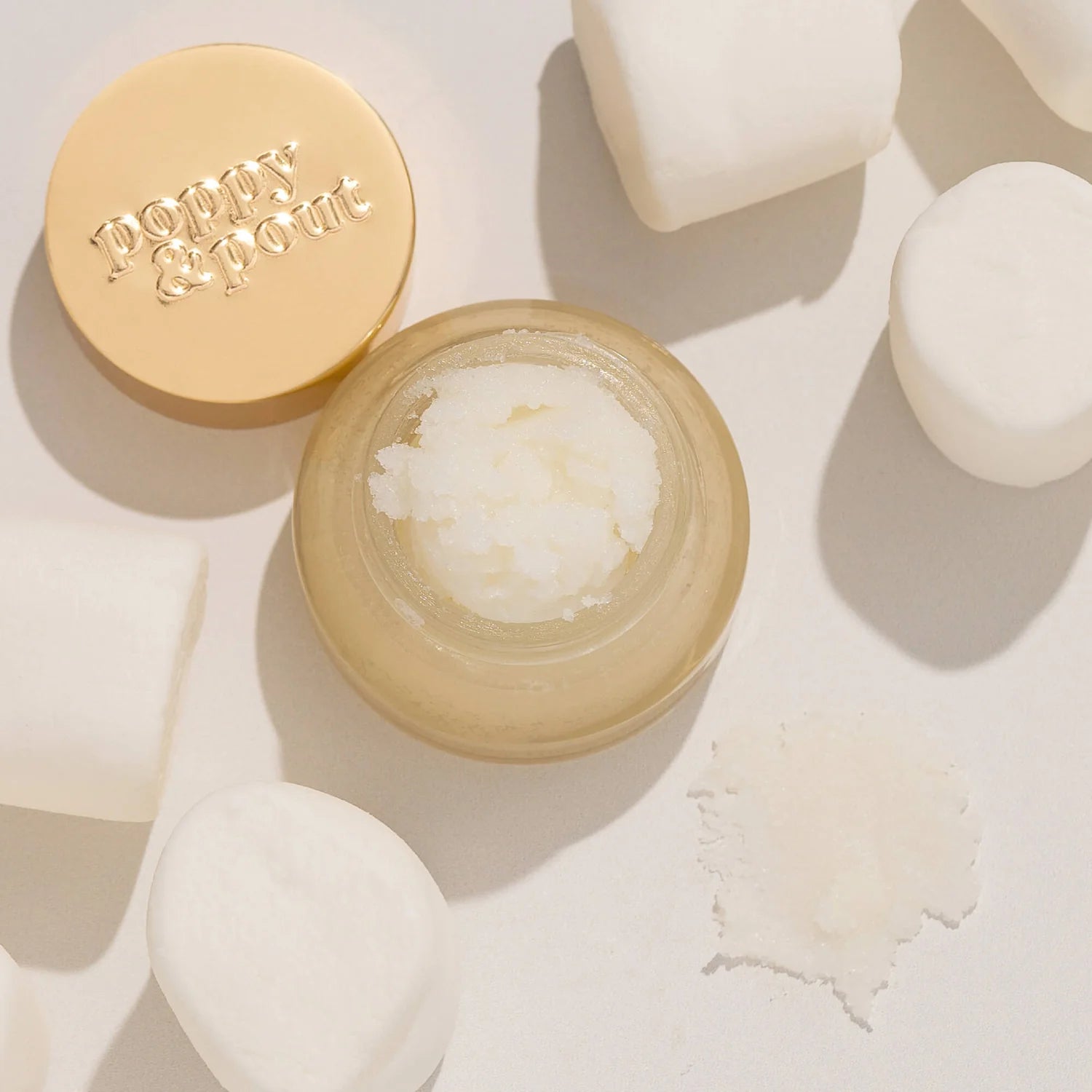 Open jar of lip balm with visible brand name on a light background