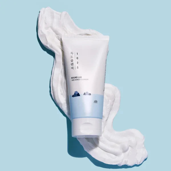 Tube of cream with a white substance on a light blue background