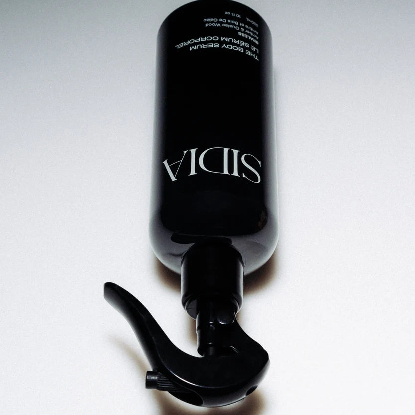 Black serum bottle with visible brand name on a white background