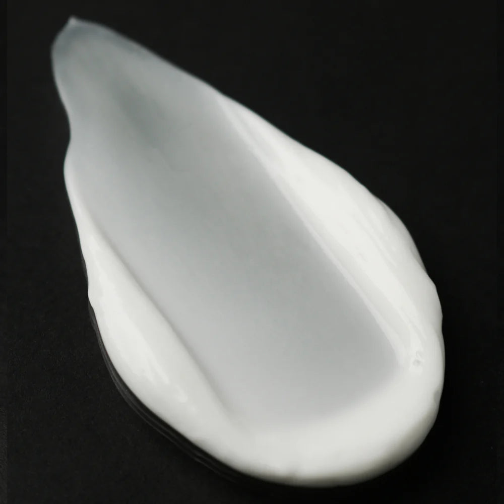 Black cosmetic tube with green cap on a white background