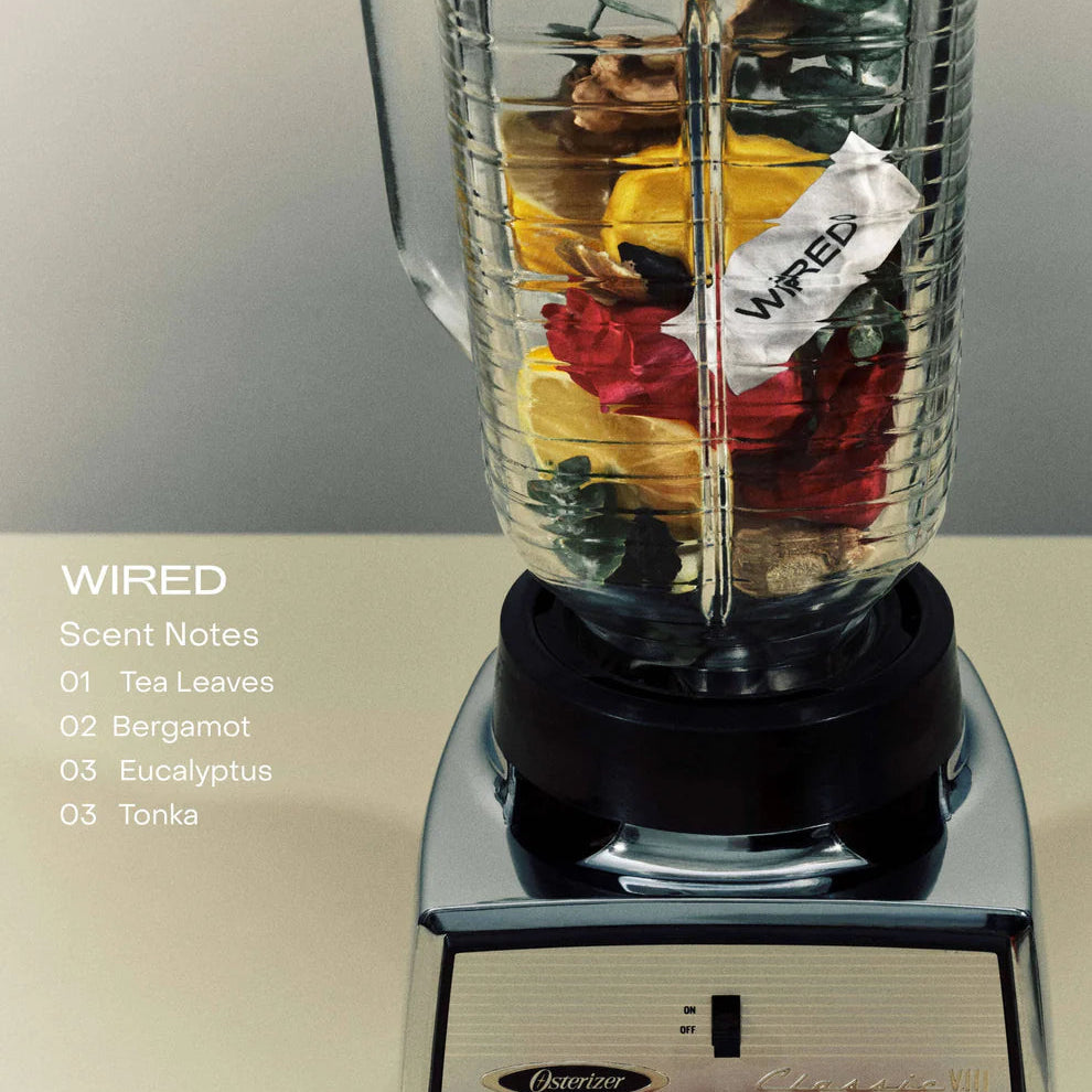 Blender with colorful tea leaves and a 'WIRED' brand label on a neutral background