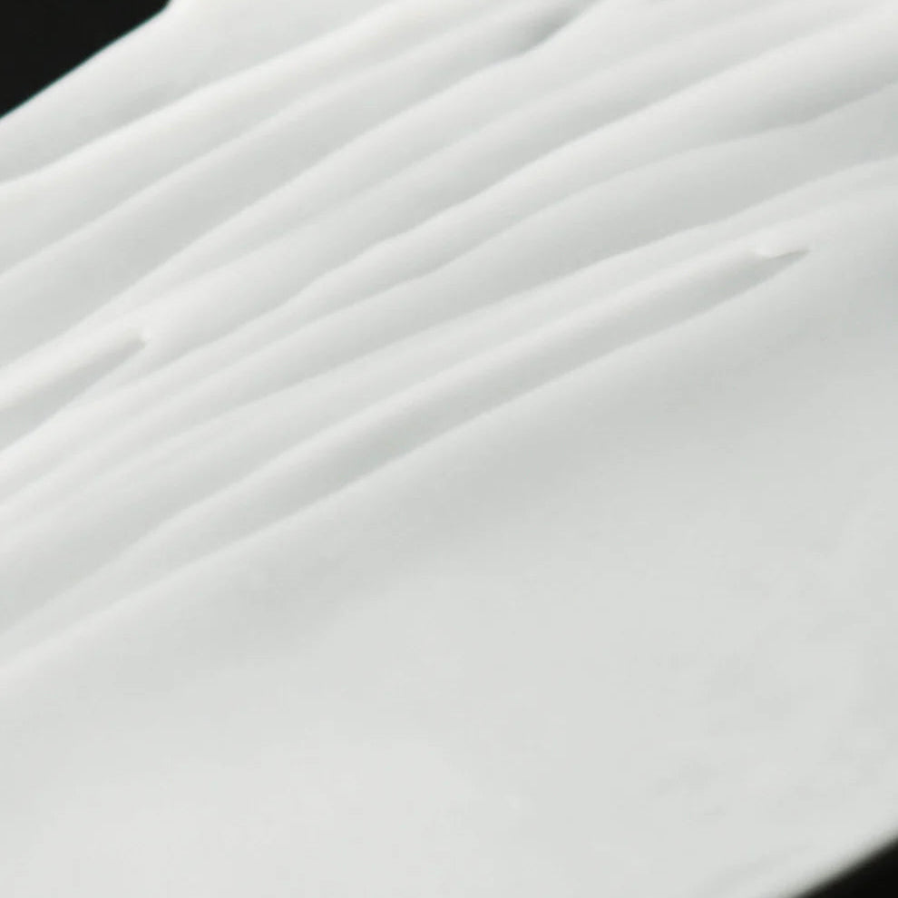 Close-up of white fabric with folds on a black background