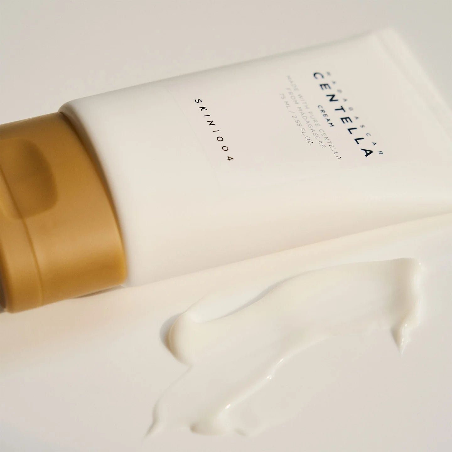 Centella skin care product with gold cap on a light background