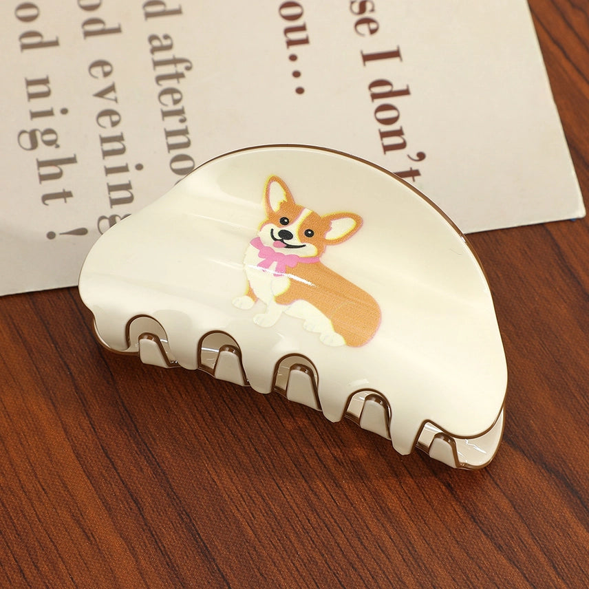 Hair clip with a corgi design on a wooden surface