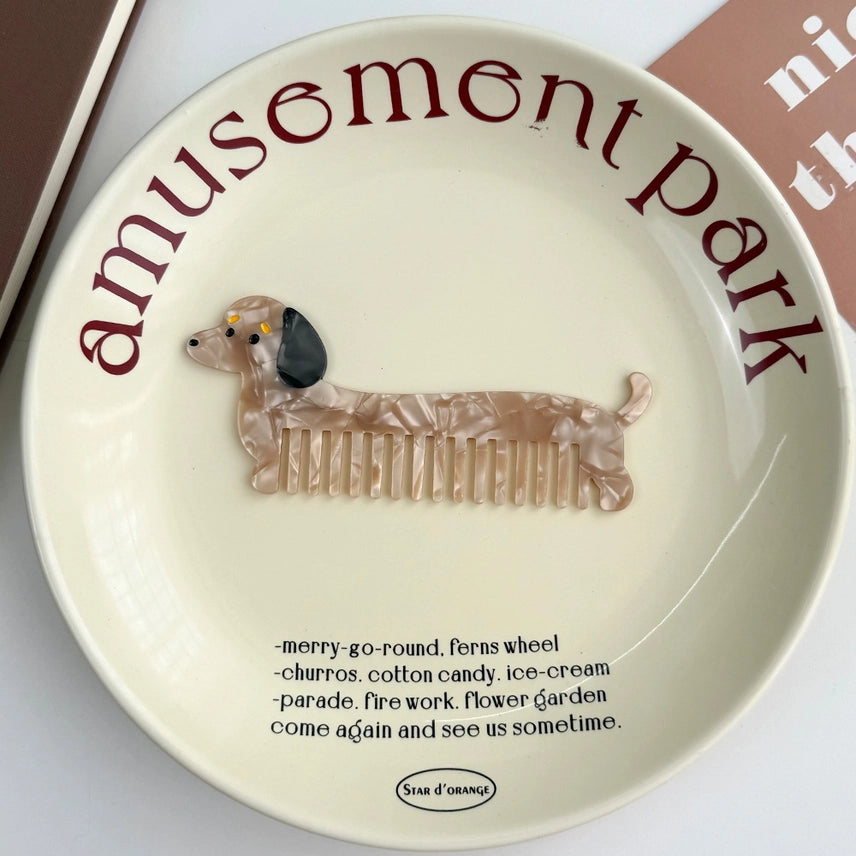 Decorative plate with a dachshund comb and 'amusement park' text on a white background