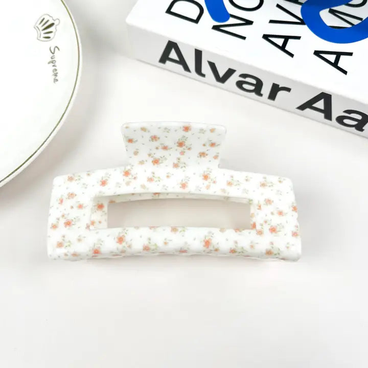 Floral patterned hair clips on a white surface with a blurred background
