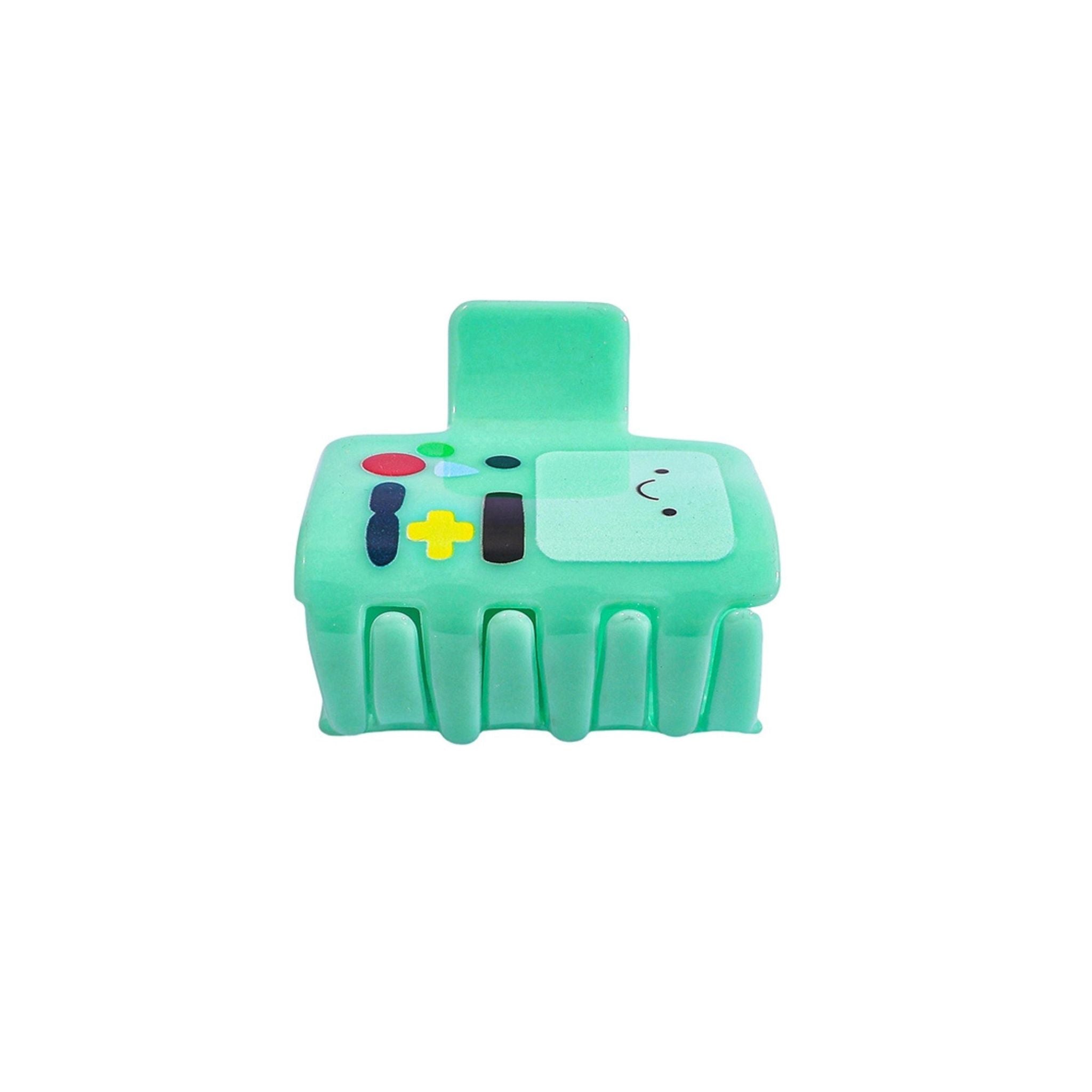 Green toy resembling a game controller with cartoon face on a white background