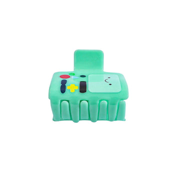 Green toy resembling a game controller with cartoon face on a white background
