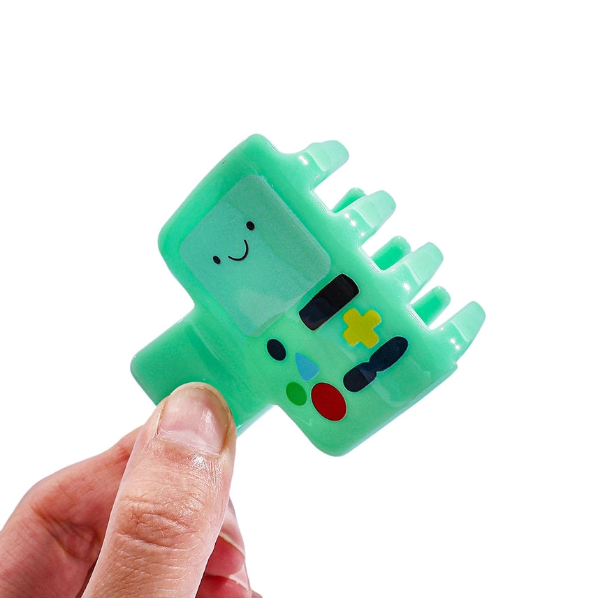 Green character-shaped toy held by a hand on a white background
