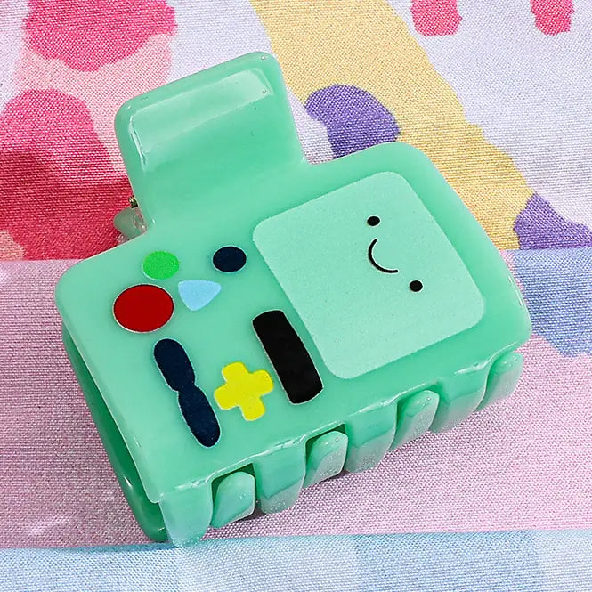 Green cartoon-like device with colorful buttons on a patterned background