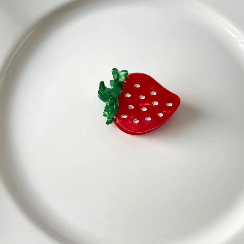 Red strawberry-shaped object on a white plate