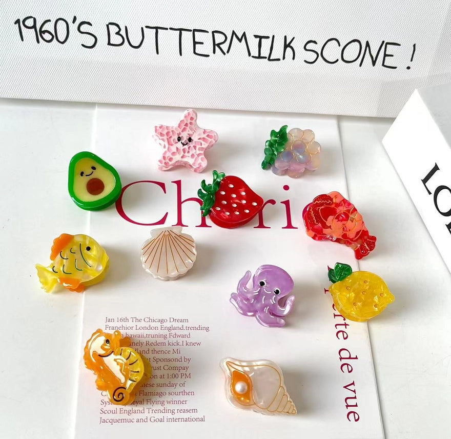 Colorful fish-shaped hair clips on a magazine with text overlay