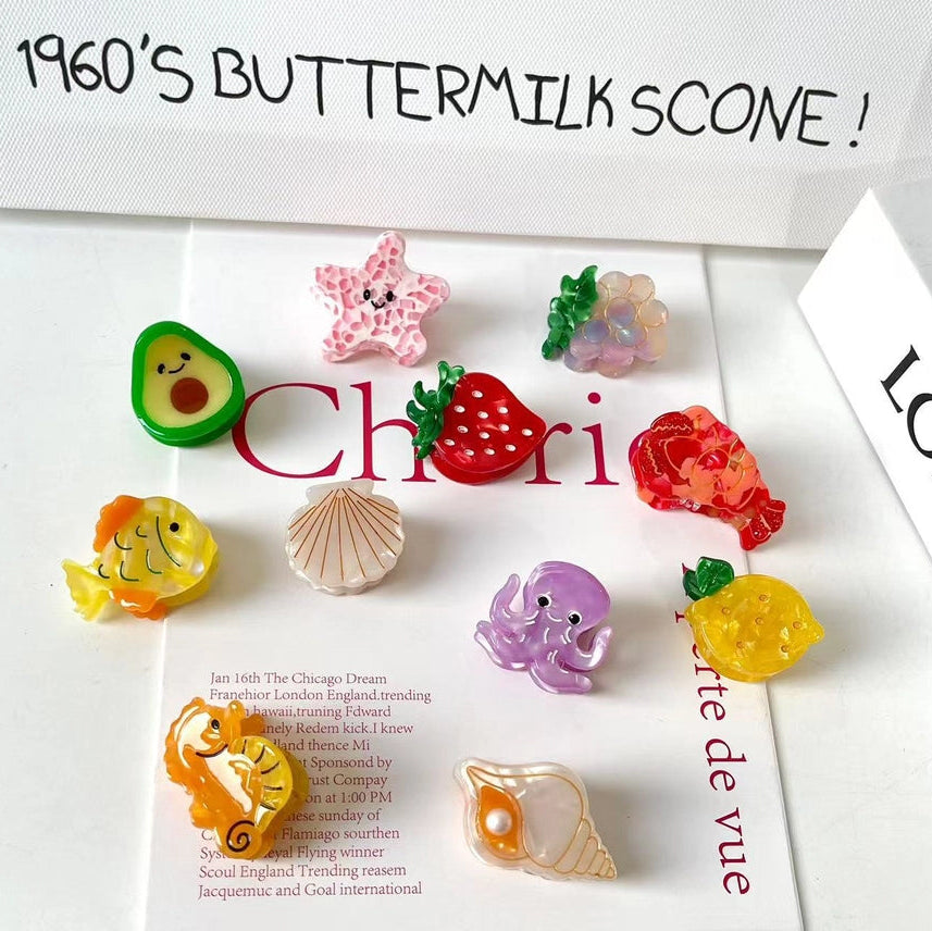 Colorful fish-shaped hair clips on a magazine with text overlay